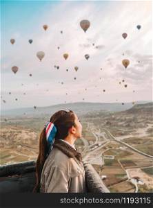 Asian woman watching colorful hot air balloons flying over the valley at Cappadocia, Turkey This Romantic time