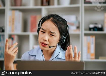 Asian woman wear headset and use laptop video call stream conference to working online while during quarantine covid-19 self isolation at home, work from home concept