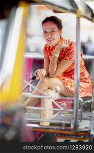 asian woman wearing chinese tradition clothes sitting in tuktuk passenger seat bangkok thailand
