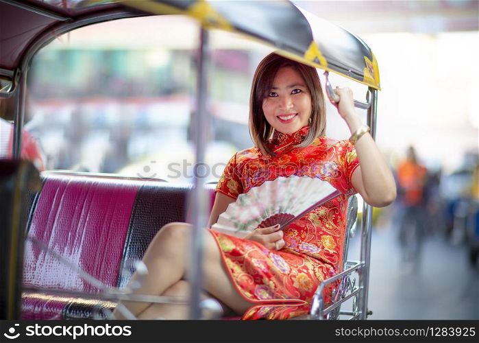 asian woman wearing chinese tradition in tuktuk thailand