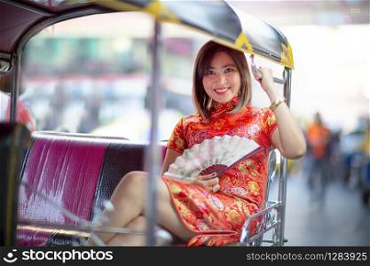 asian woman wearing chinese tradition in tuktuk thailand