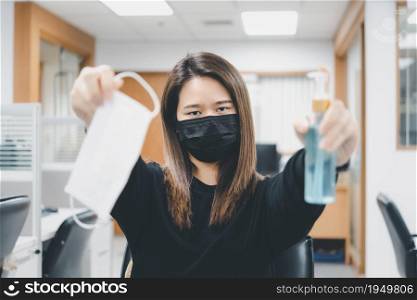 Asian woman wearing mask and alcohol antibacterial hand gel respiratory protection mask against epidemic flu covid19 or corona virus with fear emotion in concept illness, outbreak, healthcare in life. Woman wearing mask protection epidemic flu covid19