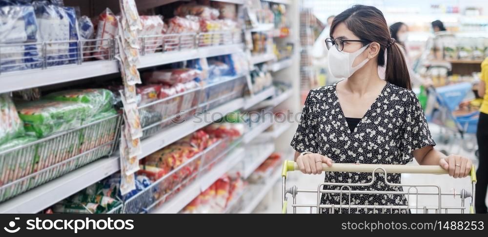 Asian woman wearing protective mask and shopping in supermarket or grocery, protect coronavirus inflection. social distancing, new normal and life after covid-19 pandemic