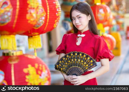 Asian woman wearing red traditional Chinese cheongsam decoration with paper lanterns with the Chinese alphabet Blessings written on it Is a Fortune blessing compliment decoration for Chinese New Year