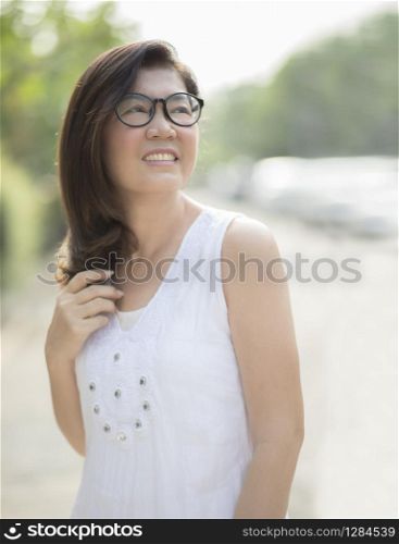 asian woman wearing white dress toothy smiling face outdoor on sunny day
