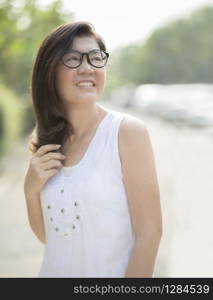 asian woman wearing white dress toothy smiling face outdoor on sunny day