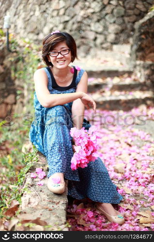 asian woman with pink flower bouquet in her hand smilling to camera. asian woman with pink flower bouquet in her hand smilling to camera with nice emotion