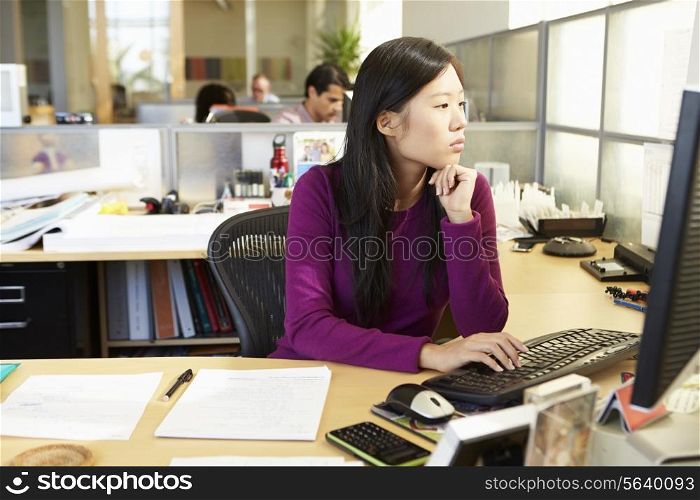 Asian Woman Working At Computer In Modern Office