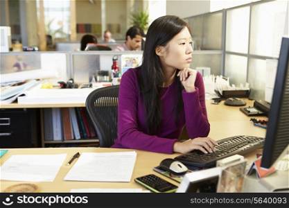 Asian Woman Working At Computer In Modern Office