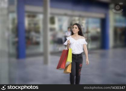 Asian women and Beautiful girl is holding shopping bags smiling while doing shopping in the supermarket/mall