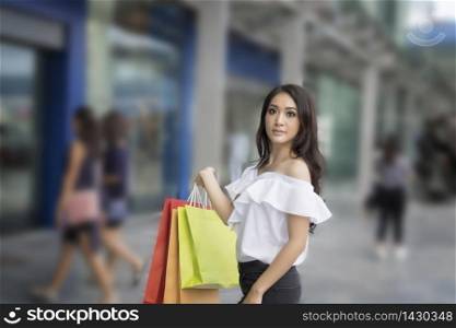 Asian women and Beautiful girl is holding shopping bags smiling while doing shopping in the supermarket/mall