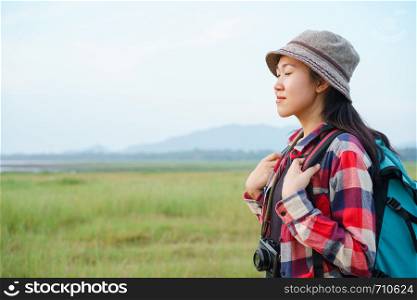 Asian women are closing their eyes and enjoying nature on the mountains and sky background. A young girl is traveling on summer vacation.