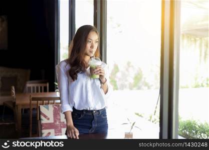 Asian women are drinking coffee and looking outside.