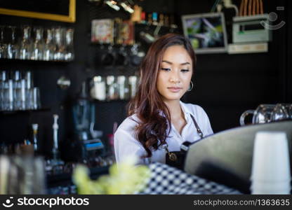 Asian women Barista smiling and using coffee machine in coffee shop counter - Working woman small business owner food and drink cafe concept