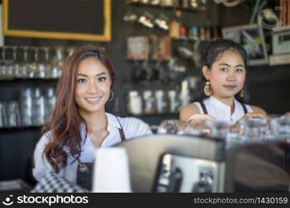 Asian women Barista smiling and using coffee machine in coffee shop counter - Working woman small business owner food and drink cafe concept