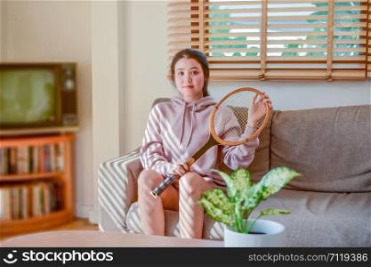 Asian women beauty cute holding tennis racket sitting in room happy smile