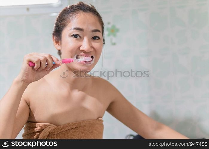 Asian women brush their teeth in the bathroom.