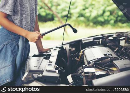 Asian women engineer holding a wrench in hand, prepared for the repairs cars on road