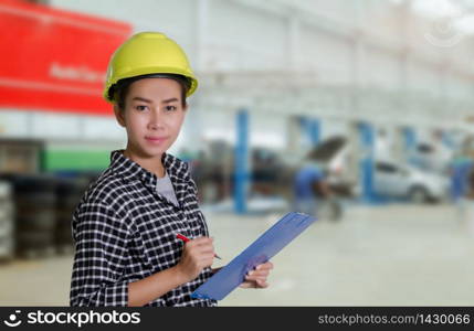 Asian women engineers and technicians mechanic are checking and inspectingthe list on the board of a car in auto repair shop