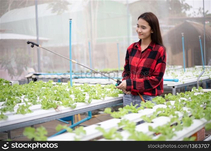 Asian women Gardeners watering vegetables in the garden.