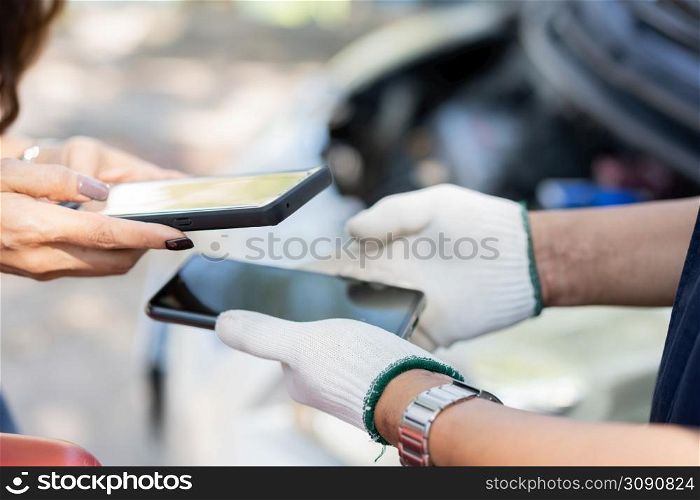 Asian women get contact numbers from Asian male auto mechanics after fixing the car engine problem and QR code scan to pay for fixing vehicle service. Car repair, and maintenance concept.
