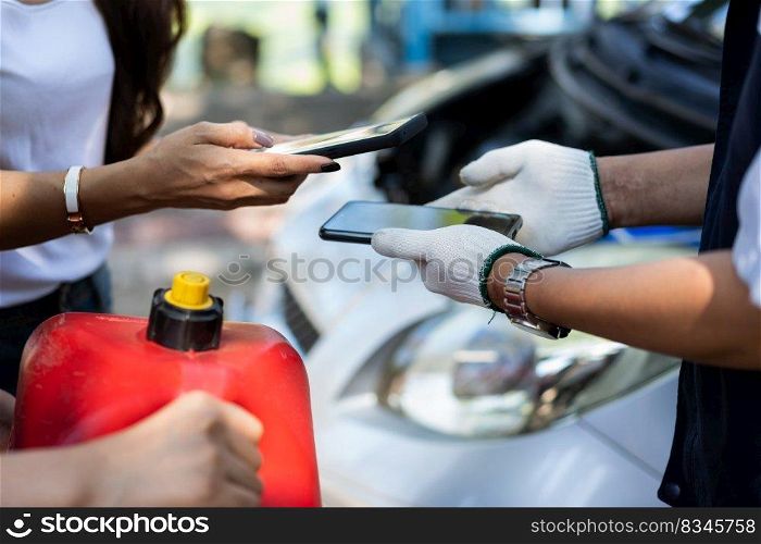 Asian women get contact numbers from auto mechanics after fixing the car engine problem and QR code scan to pay for gas after running out of fuel on the road. Car repair and maintenance concept.