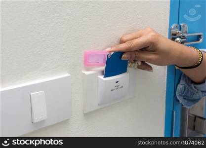 Asian women hand hold card for door access control scanning key card to lock and unlock door.
