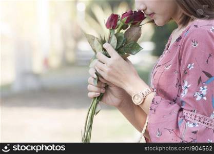 Asian women holding red rose in pink dress