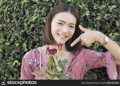 Asian women holding red rose in pink dress,Valentine concept