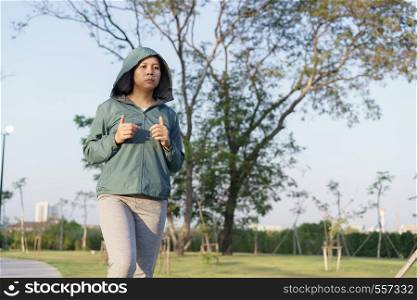 Asian women jogging in the morning garden , healthy lifestyle and sport concept