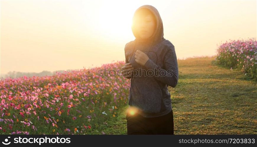 Asian women Jogging on morning at cosmos flower field