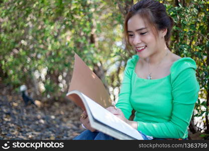 Asian women reading book and smiling and happy Relaxing in a coffee shop after working in a successful office.