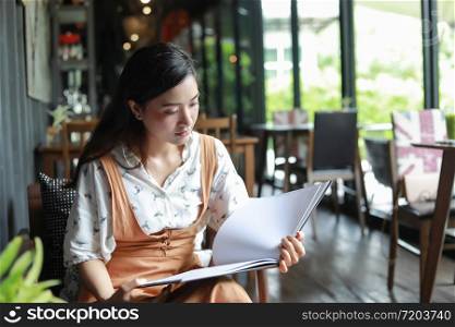 Asian women reading book and smiling and happy Relaxing in a coffee shop