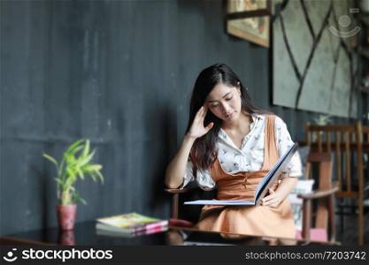 Asian women reading book and smiling and happy Relaxing in a coffee shop