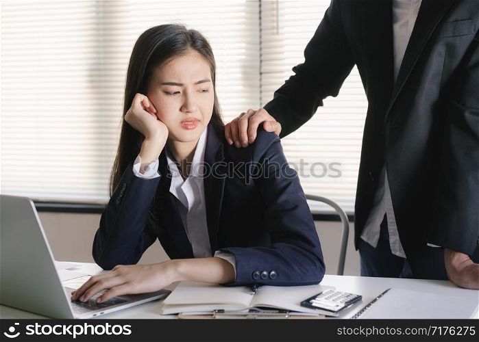 Asian women sexual harassment at working in the office Manager putting his hand on the shoulder of his