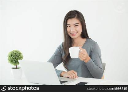 Asian women sit in office with coffee.