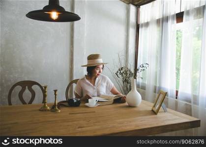asian women sitting and reading book, looking to window