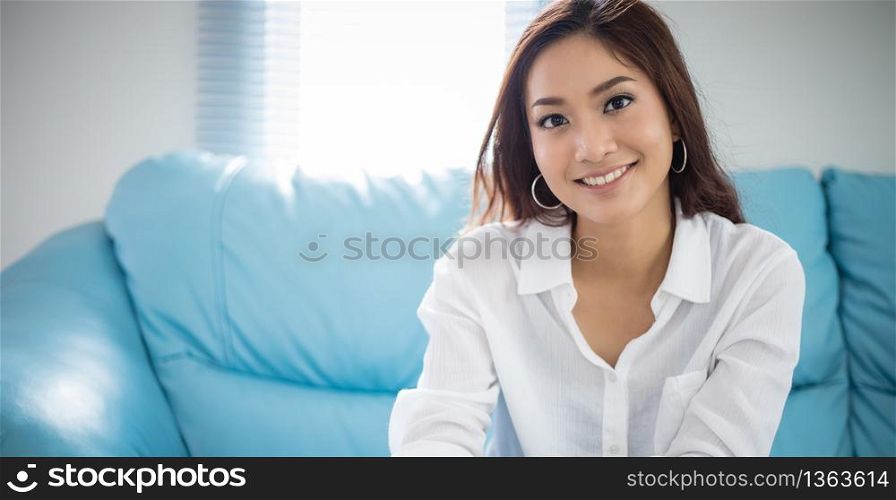 Asian women sitting relaxation on sofa and she is smiling happy at home