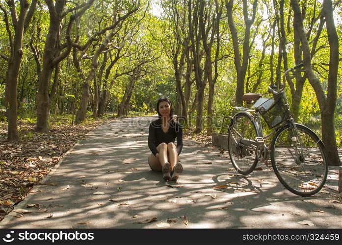 Asian women sitting while resting from cycling in the park