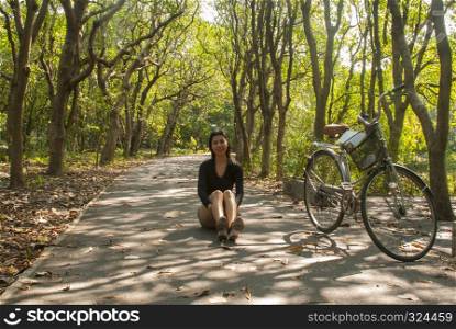 Asian women sitting while resting from cycling in the park