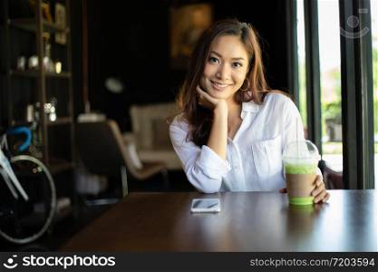Asian women smiling and happy Relaxing in a coffee shop after working in a successful office.