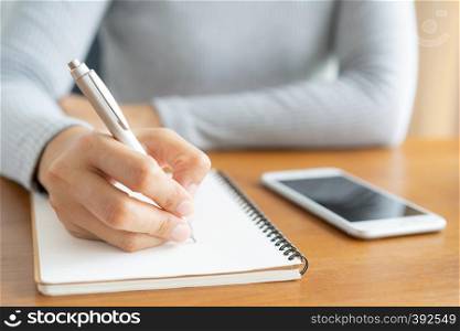 Asian women take notes with a pen in the office, business woman working on table