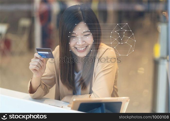 Asian women using the technology tablet for access control by face recognition in private identification step when online shopping with the credit card, credit card mockup, online payment concept,