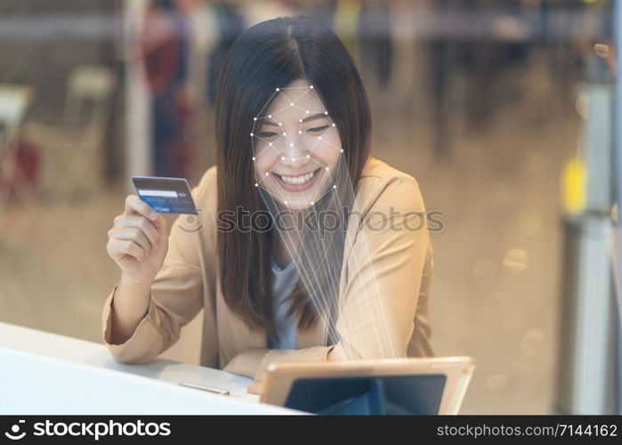 Asian women using the technology tablet for access control by face recognition in private identification step when online shopping with the credit card, credit card mockup, online payment concept,