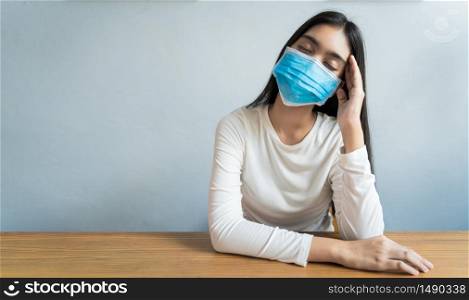 Asian women wear a mask are holding their heads because of headaches. She has a fever and migraine because of stress or sleep late, low sleep, insufficient rest in healthy concept with copy space