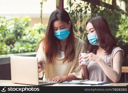 Asian women wearing mask to protect virus and working from home. New Normal and Technology concept.