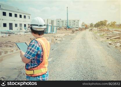 Asian women worker and engineer on building site using tablet for checking the accuracy in places before building and houses.