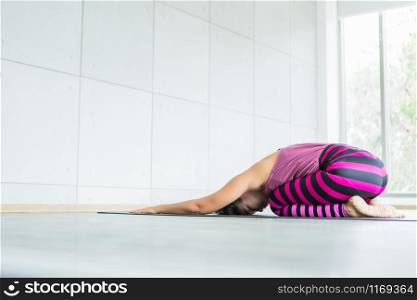 Asian women workout practicing yoga training put on pink clothes and practice meditation wellness lifestyle and health fitness concept in a gym