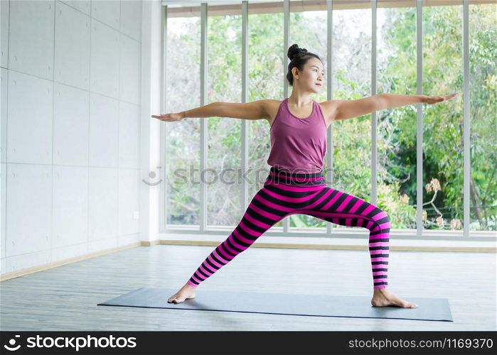 Asian women workout practicing yoga training put on pink clothes and practice meditation wellness lifestyle and health fitness concept in a gym