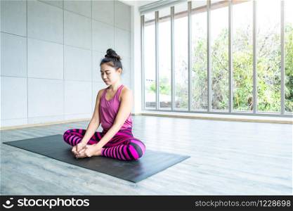 Asian women workout practicing yoga training put on pink clothes and practice meditation wellness lifestyle and health fitness concept in a gym,copy space